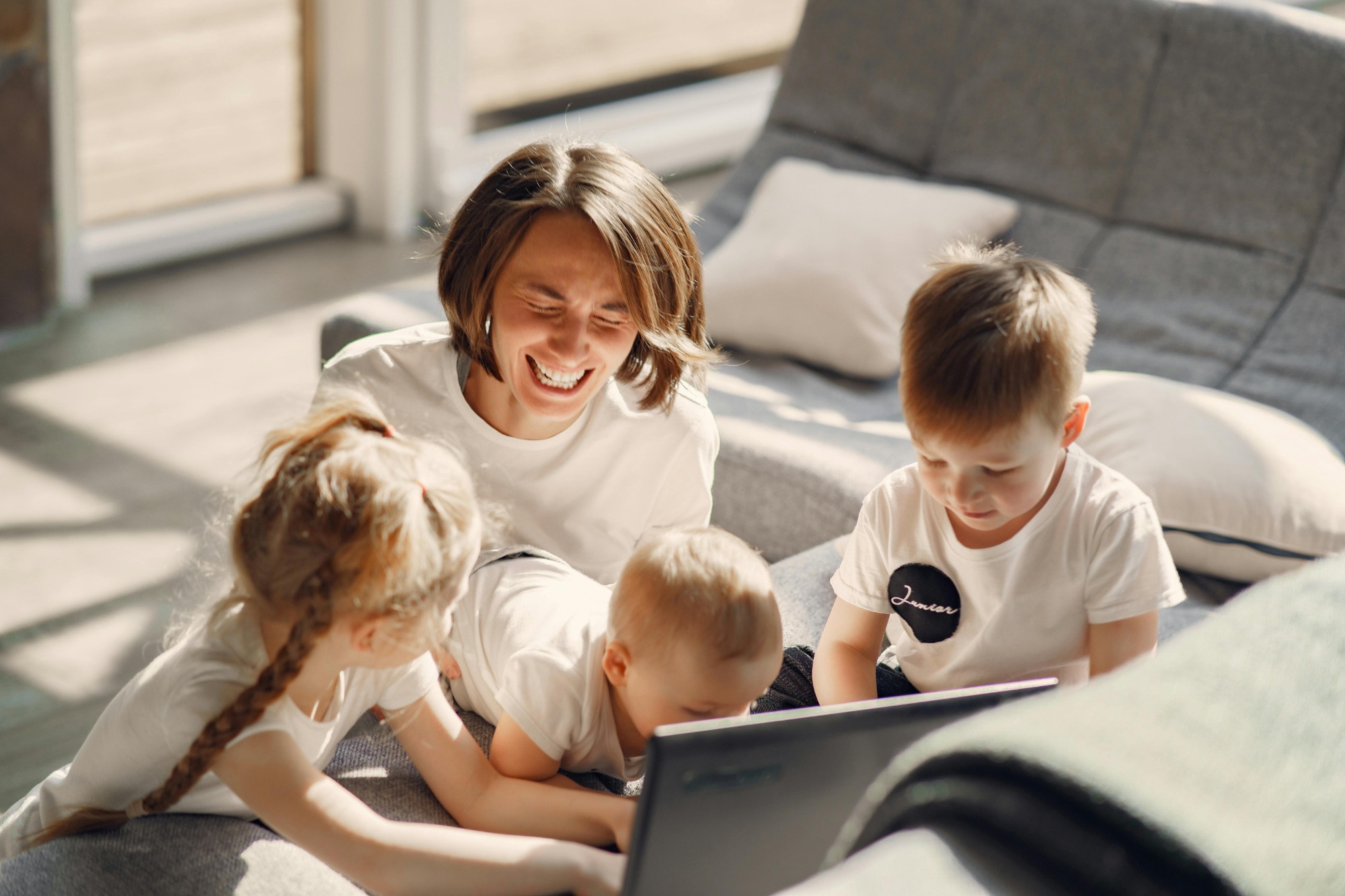 Mom with kids, laughing and playing the living room