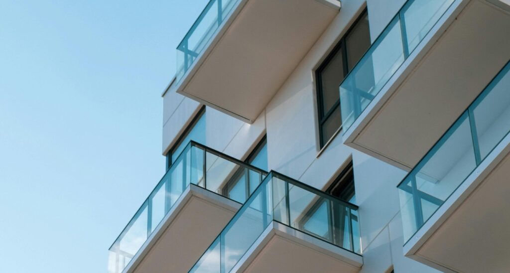 apartment building or condo with glass balconies, view looking up.