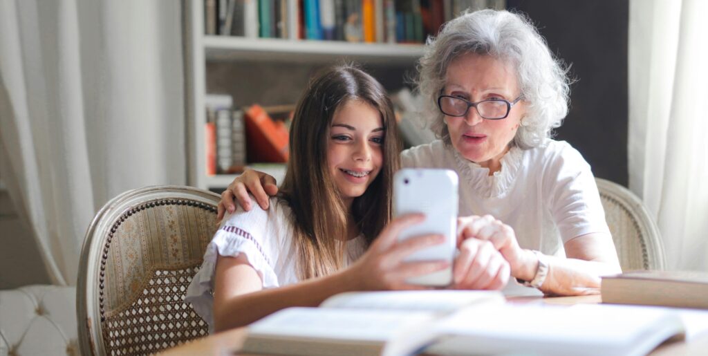 Grandmother sitting with Granddaughter booking Tidy Bird Cleaning house cleaning online, with instant quote.
