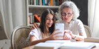Grandmother sitting with Granddaughter booking Tidy Bird Cleaning house cleaning online, with instant quote.